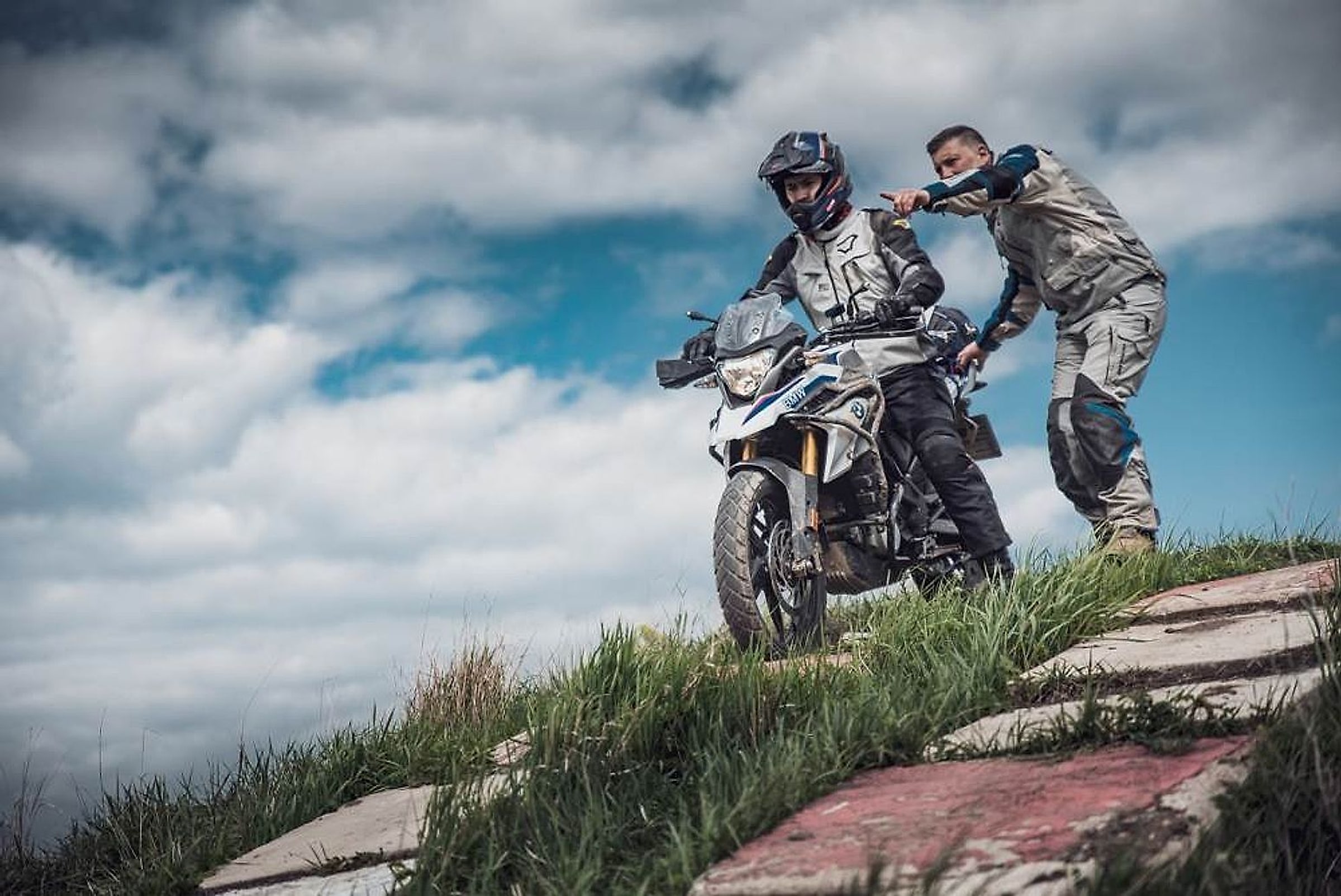 Instruktor radí jezdci na BMW F 850 GS při výjezdu do terénního kopce