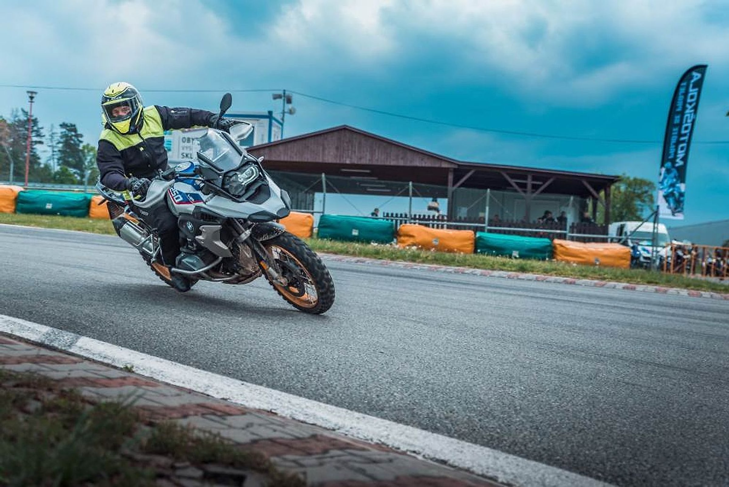Jezdec v reflexní bundě na BMW GS projíždí zatáčkou okruhu ve Vysokém Mýtě