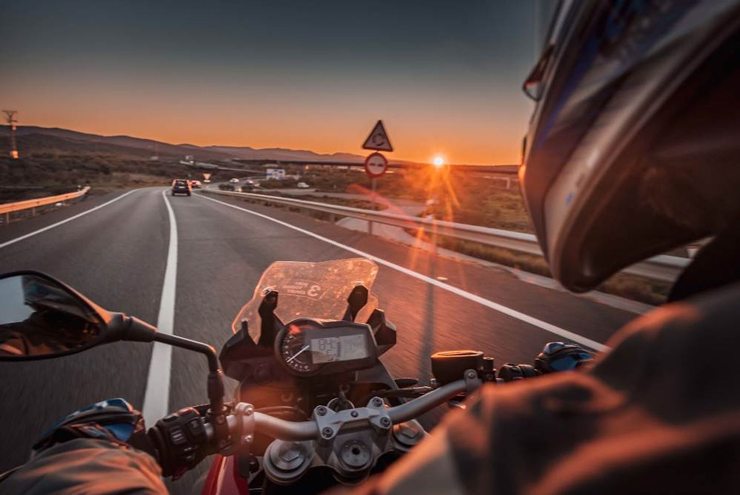 Pohled z motorky na španělskou silnici při západu slunce