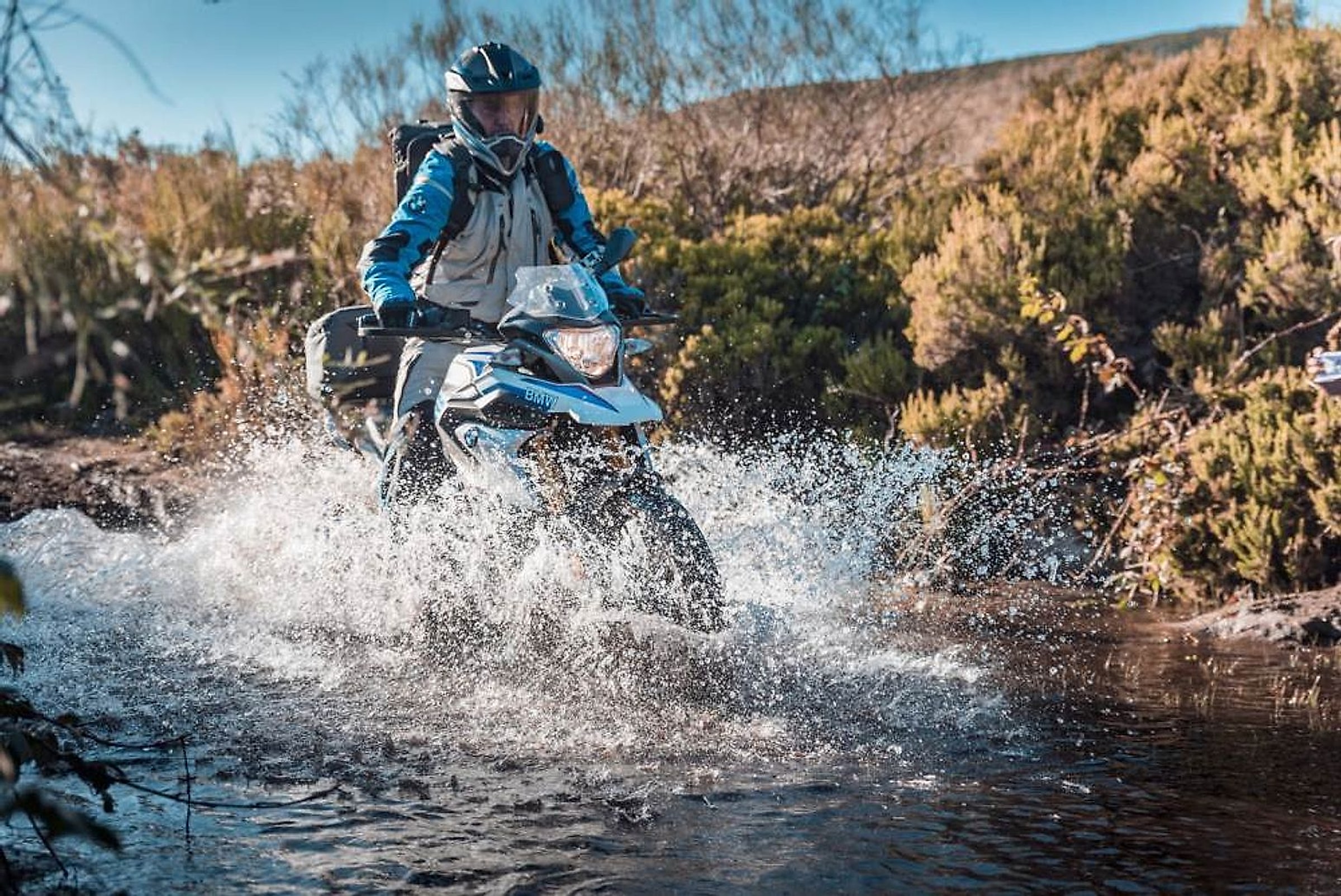 Jezdec na BMW GS projíždí brodem v horách během expedice