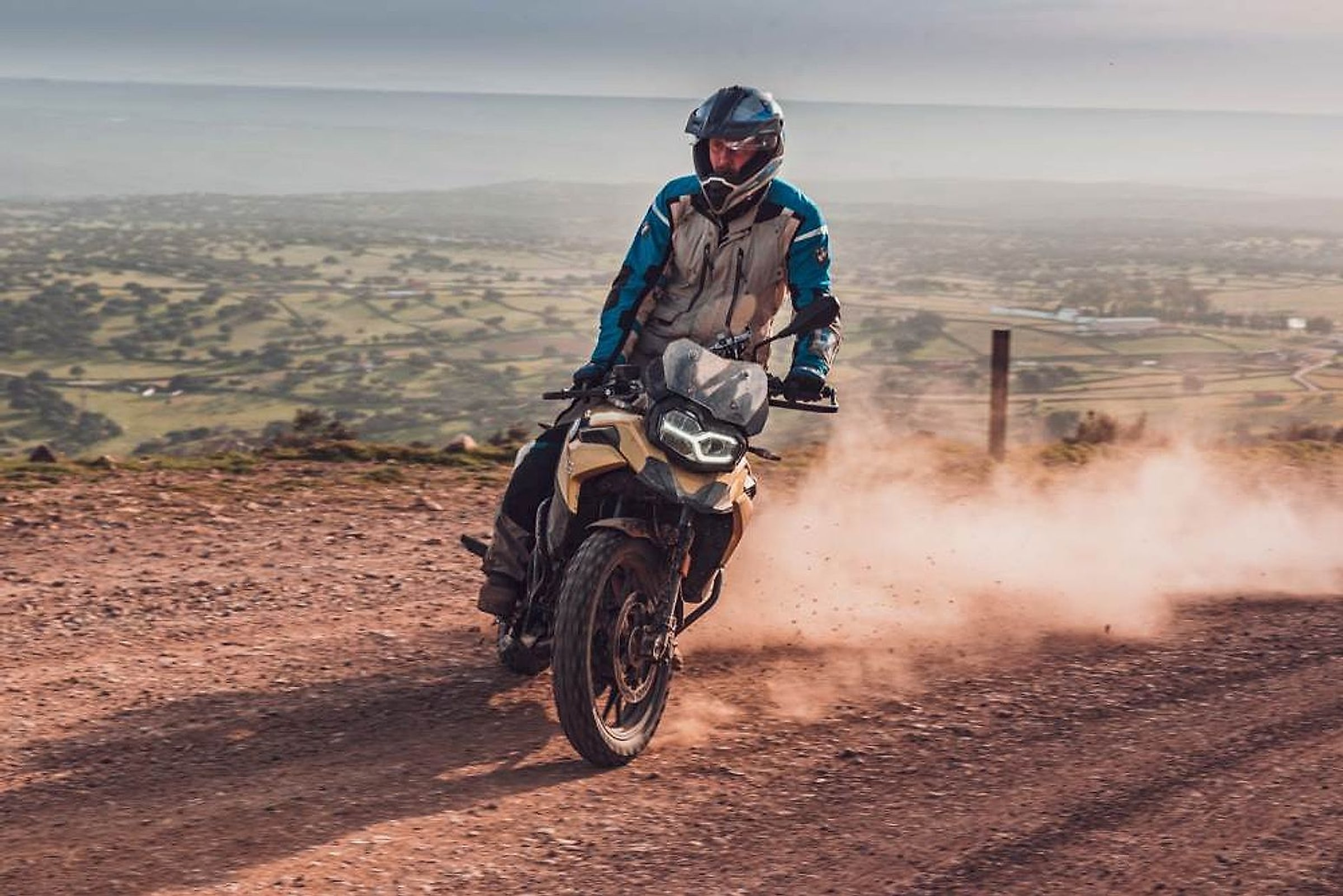 Jezdec na BMW F 850 GS na šotolinové cestě nad španělskou krajinou