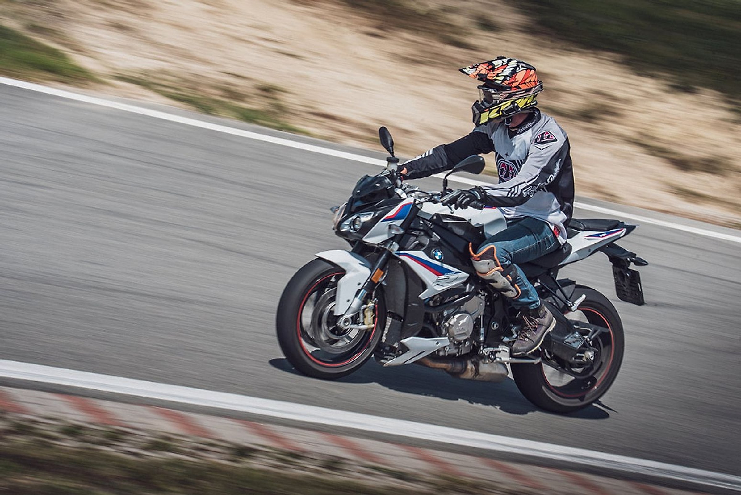 Jezdec na motorce BMW S 1000 R v náklonu na závodním okruhu
